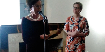 La embajadora Tiina Jortikka-Laitinen se dirige a los invitados en presencia de la ministra de Medio Ambiente, Krista Mikkonen.