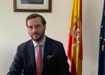 Daniel Losada Millar posando en su oficina con banderas de España y Europa