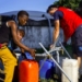 Personas llenando recipientes con agua potable en Mozambique tras inundaciones.