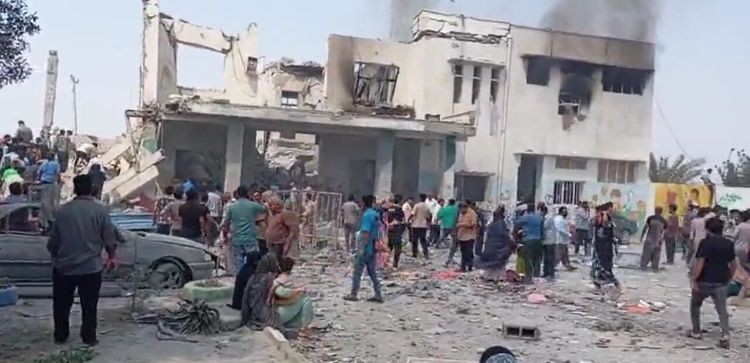 Escena de un ataque militar en Irán con edificios dañados y multitud de personas.