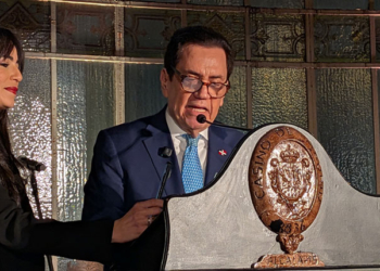 El embajador hablando en un evento con Crismeidy Ureña a su lado