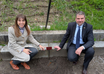 El embajador de Eslovenia y la directora del jardín posando junto a la vid plantada.