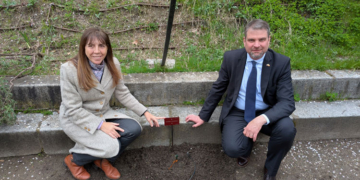 El embajador de Eslovenia y la directora del jardín posando junto a la vid plantada.
