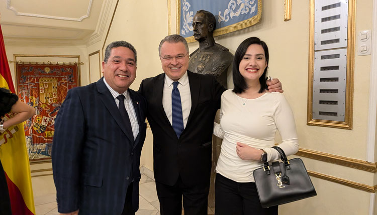Alberto Camacho posando con el embajador y una mujer en un evento