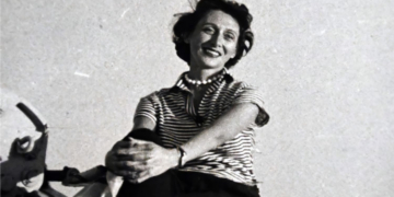 Mujer sonriente en una exposición sobre arquitectura femenina