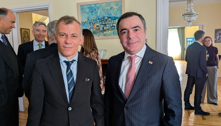 Dos hombres en trajes formales en una recepción diplomática en la embajada irlandesa.