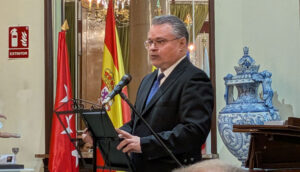 El embajador de Bulgaria hablando en un evento con banderas de España y Bulgaria.