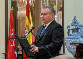 El embajador de Bulgaria hablando en un evento con banderas de España y Bulgaria.