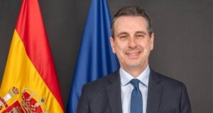 Retrato del embajador de España en Irán con banderas de fondo