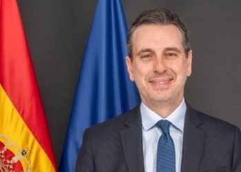 Retrato del embajador de España en Irán con banderas de fondo