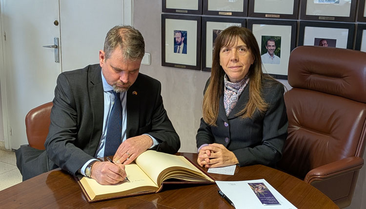 El embajador de Eslovenia firma un libro junto a la directora del jardín botánico.