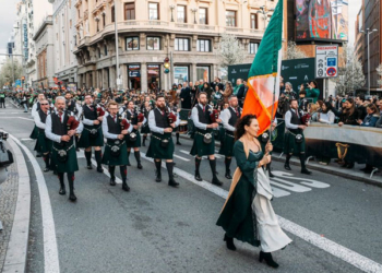 Desfile de San Patricio en la Gran Vía de Madrid con gaiteros y banderas irlandesas.