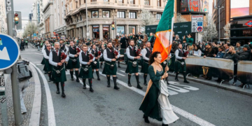 Desfile de San Patricio en la Gran Vía de Madrid con gaiteros y banderas irlandesas.