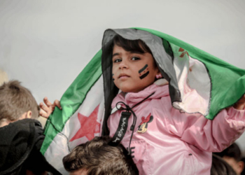Niña con bandera siria en una manifestación por la paz en Siria