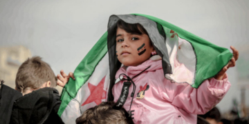 Niña con bandera siria en una manifestación por la paz en Siria
