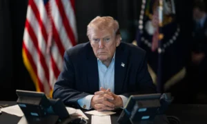 Donald Trump sentado frente a teléfonos con expresión seria