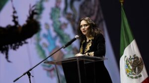 Isabel Díaz Ayuso hablando en un evento en México con bandera de México de fondo
