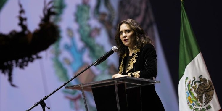 Isabel Díaz Ayuso hablando en un evento en México con bandera de México de fondo