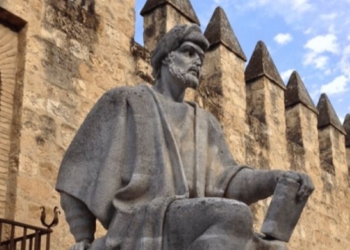 Estatua de Averroes en Córdoba, España, frente a un muro antiguo.