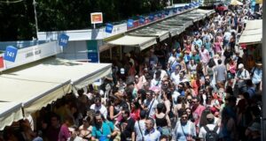 Multitud de personas en la Feria del Libro de Madrid con puestos de libros