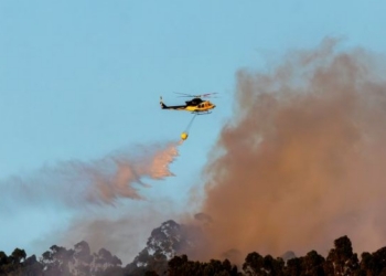 Helicóptero lanzando agua para apagar un incendio forestal