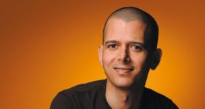 Retrato del escritor marroquí Abdellah Taïa con fondo naranja