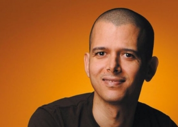 Retrato del escritor marroquí Abdellah Taïa con fondo naranja