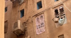 Vista de un edificio tradicional en Yemen con un hombre en la ventana