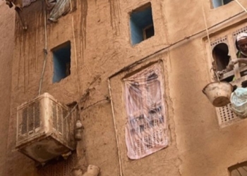 Vista de un edificio tradicional en Yemen con un hombre en la ventana