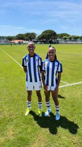 Two young South African footballers in team uniforms on a field