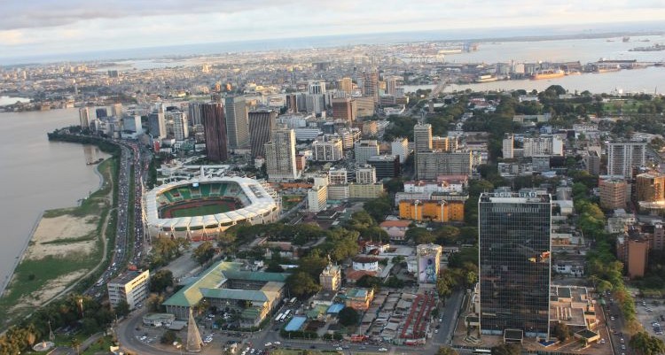 Vista panorámica de Abiyán, Costa de Marfil, con edificios y un estadio.
