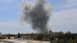 Nube de humo tras un ataque en Irán con edificios al fondo