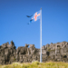 Bandera de Islandia ondeando contra un cielo azul claro.