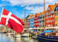 Vista del puerto de Copenhague con casas coloridas y bandera danesa