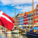 Vista del puerto de Copenhague con casas coloridas y bandera danesa
