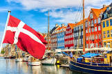 Vista del puerto de Copenhague con casas coloridas y bandera danesa