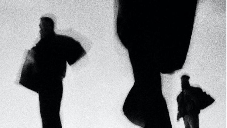 Fotografía en blanco y negro de personas en movimiento con abrigos