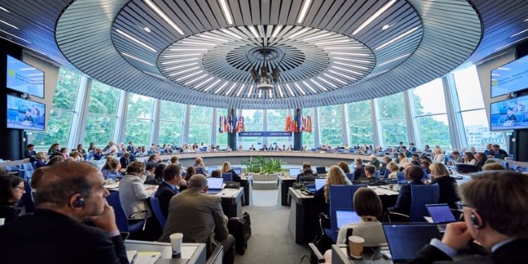Reunión de la Comisión Internacional de Reclamaciones para Ucrania con participantes en una sala moderna.
