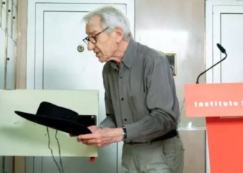 José Sacristán entregando un sombrero y un proyector en un evento