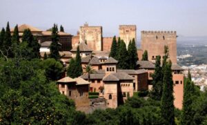 Vista panorámica de la Alhambra en Granada, España, rodeada de vegetación.