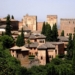 Vista panorámica de la Alhambra en Granada, España, rodeada de vegetación.