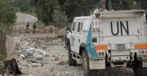Vehículo militar de la ONU en Líbano con soldados de fondo
