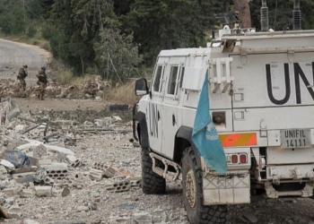 Vehículo militar de la ONU en Líbano con soldados de fondo