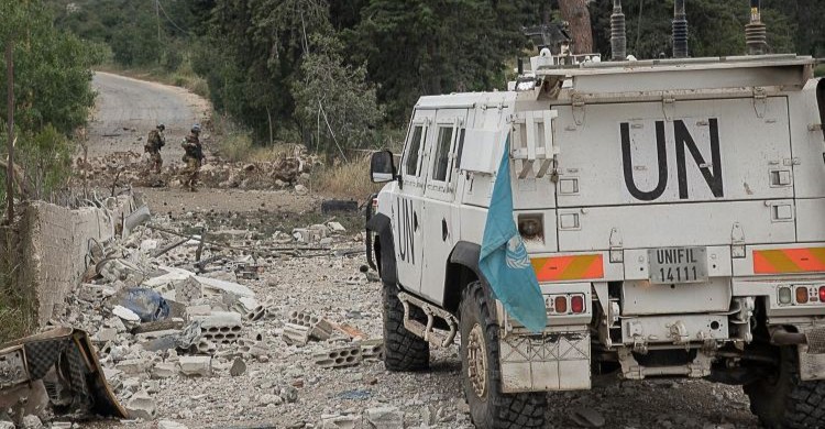 Vehículo militar de la ONU en Líbano con soldados de fondo
