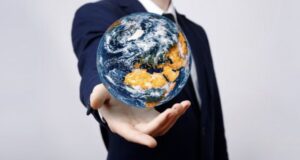 Hombre en traje sosteniendo un globo terráqueo en la mano.