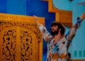 Hombre bailando en un entorno colorido con puertas decoradas