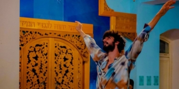 Hombre bailando en un entorno colorido con puertas decoradas