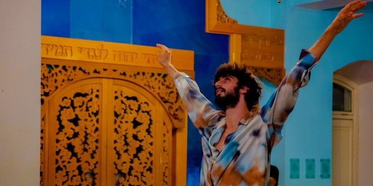 Hombre bailando en un entorno colorido con puertas decoradas