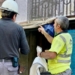 Dos trabajadores discutiendo en un sitio de construcción con señales de seguridad