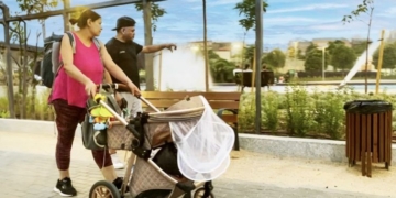 Mujer empujando un cochecito de bebé en un parque